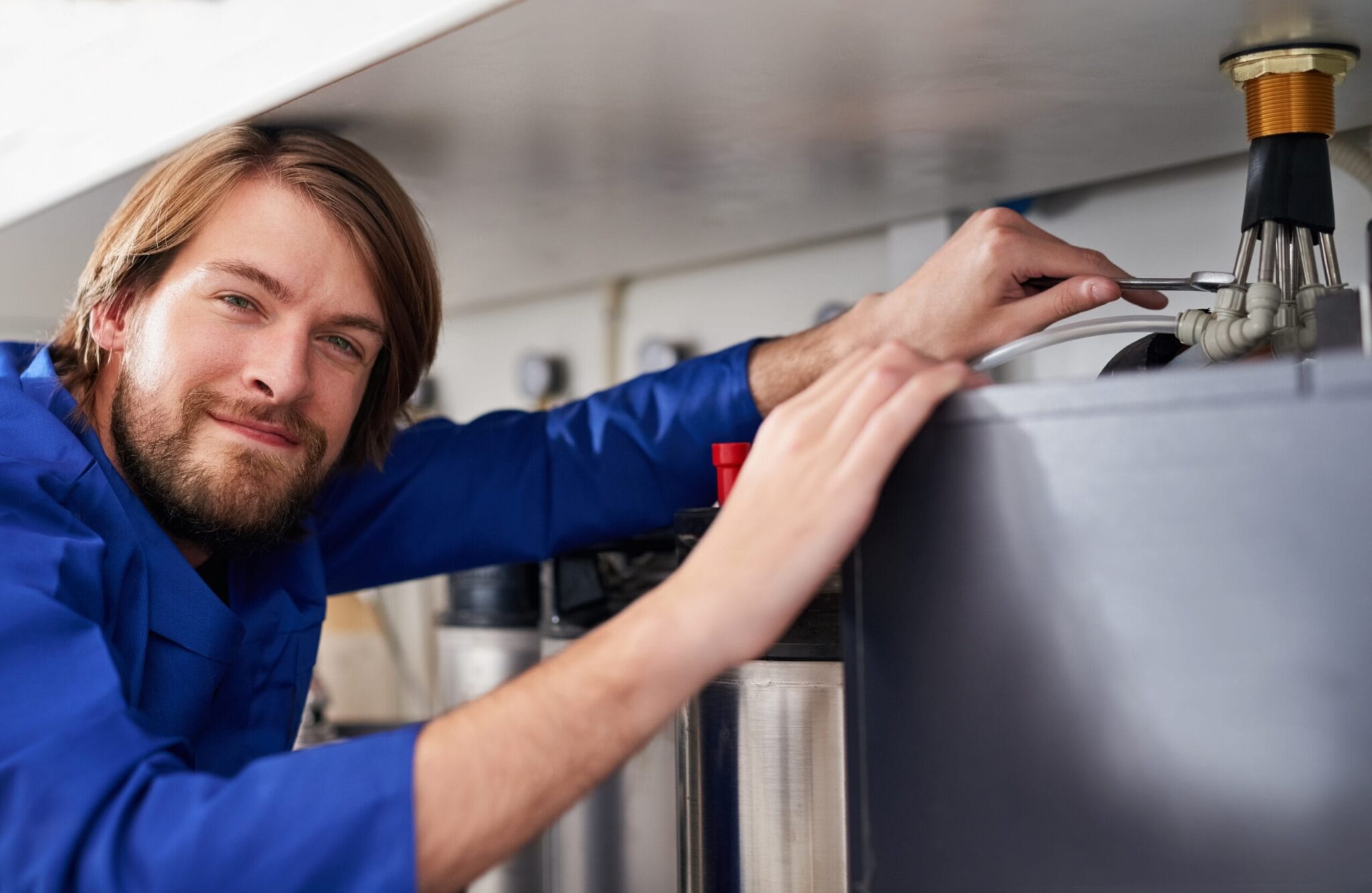 Technician servicing a residential water heater tank in Lemon Grove